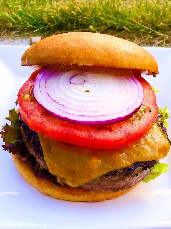 Cheeseburger mit Tomate, Salat und Zwiebel