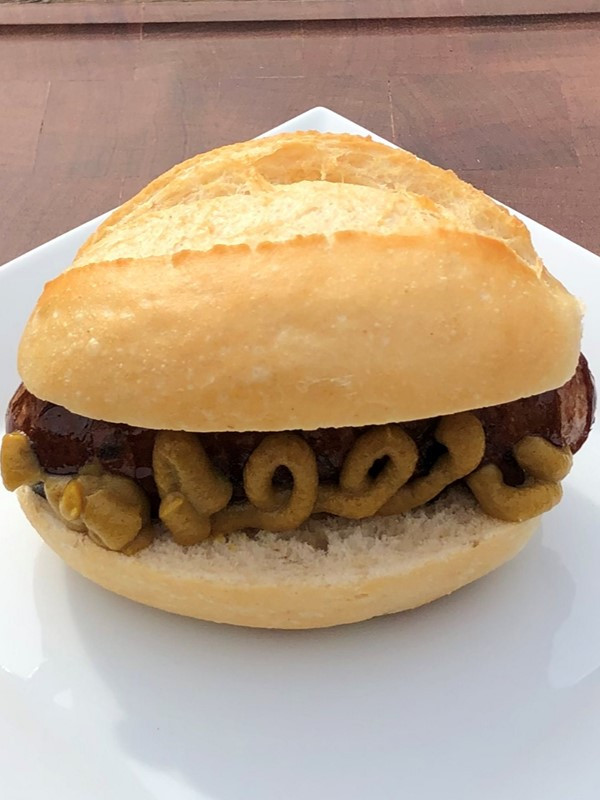 Rote Wurst im Brötchen mit Senf