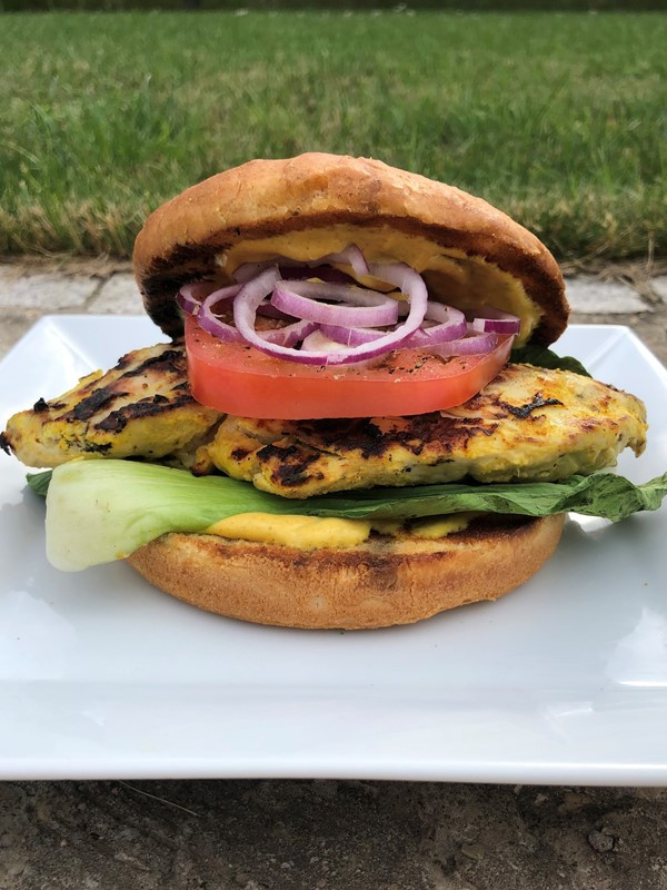 Yellow Chicken im Burger mit Pak Choi, Tomaten, Zwiebeln und Sauce